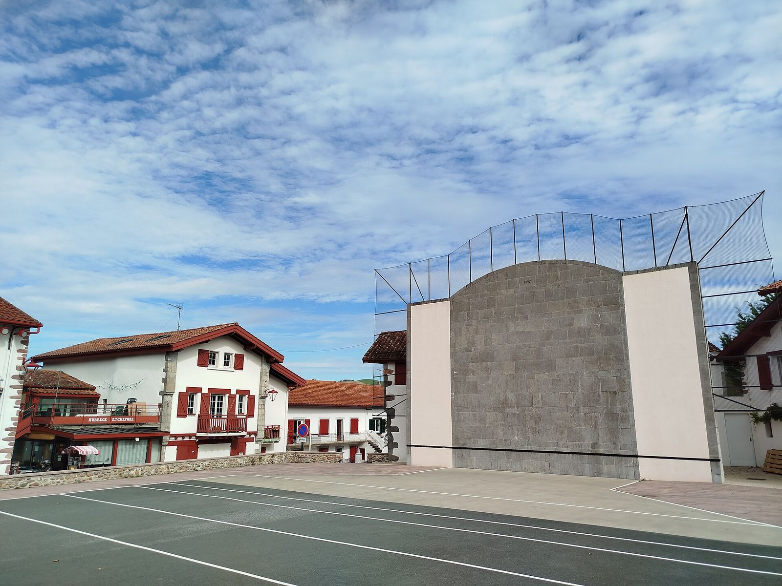 Fronton de pelote basque et maisons à volets rouges
