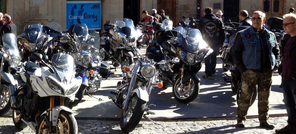 Rassemblement de motos sur une place pavée, motards en cuir